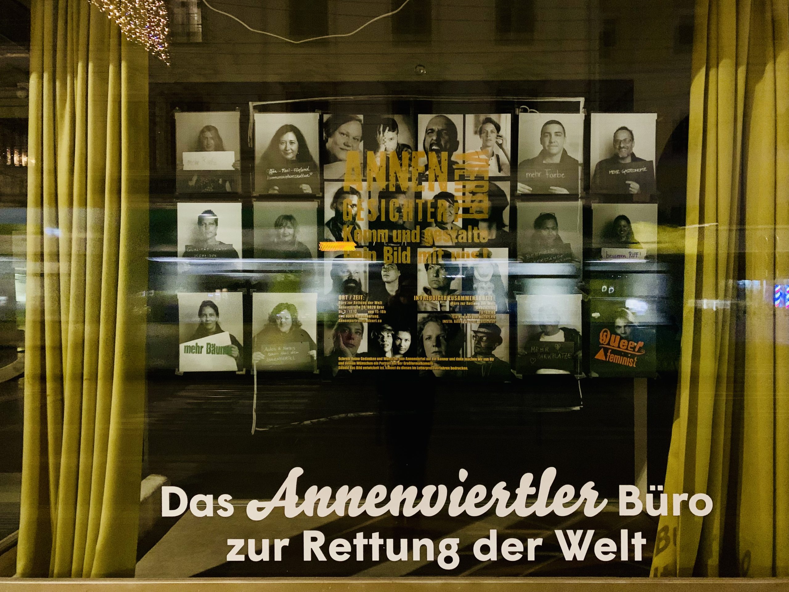 Eine Menge Porträts von Viertelbewohner:innen im Schaufenster des Büros zur Rettung der Welt.