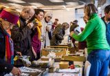 Menschen treffen sich an einem Stand, um Saatgut zu tauschen und verschenken