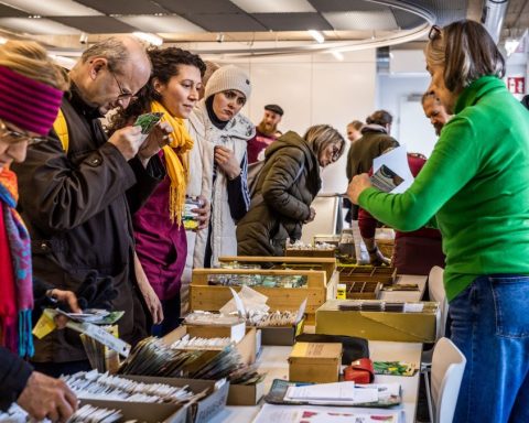 Menschen treffen sich an einem Stand, um Saatgut zu tauschen und verschenken